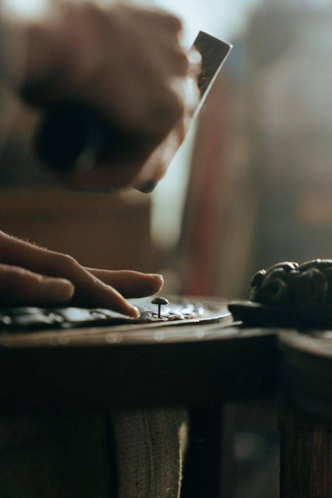 Close-up of a craftsman restoring wooden furniture with precision and skill.