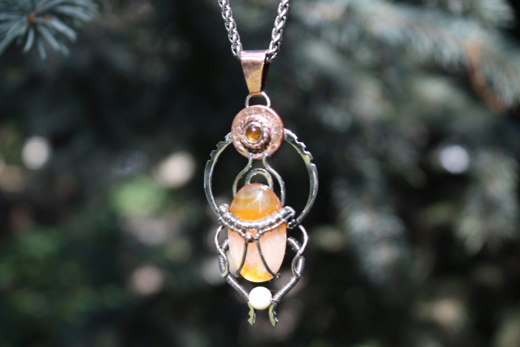 Ornate pendant with amber and pearl stones